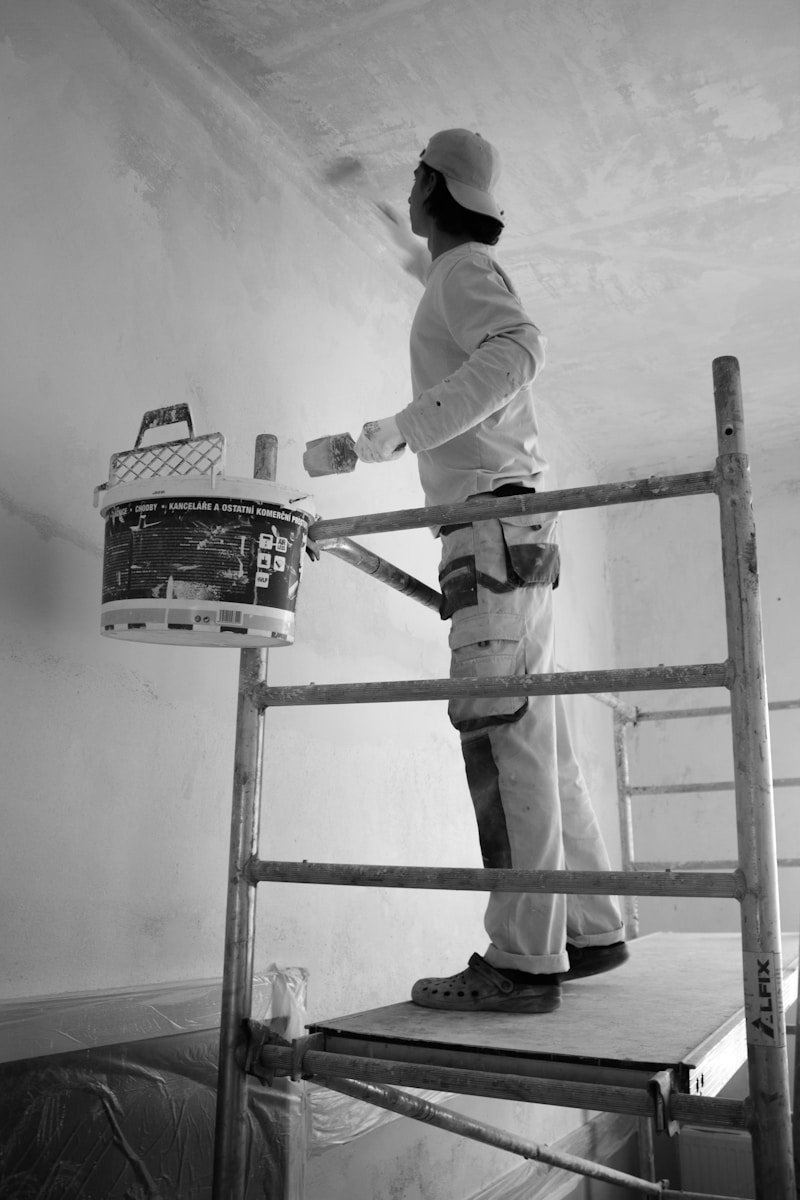 Servicios de Mantenimiento y Reformas en Parla. a man painting a wall with a paint roller